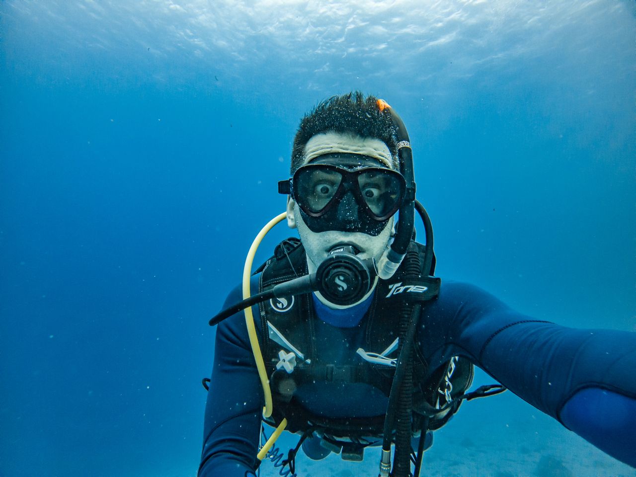 Scuba diver exploring the deep blue sea with scuba gear underwater, capturing adventure.